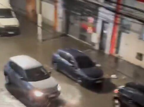 Carros passam por rua alagada em São Paulo