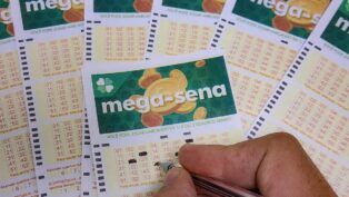 Uma mão assinala números na cartela da Mega-Sena
