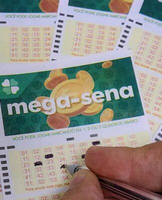 Uma mão assinala números na cartela da Mega-Sena