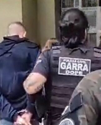 Policiais conduzem suspeito até a delegacia