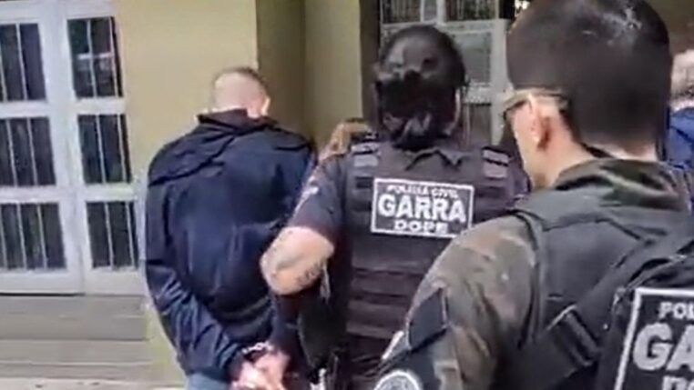 Policiais conduzem suspeito até a delegacia