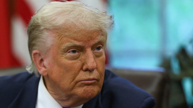 O presidente dos Estados Unidos, Donald Trump, observa enquanto assina decretos e proclamações no Salão Oval da Casa Branca