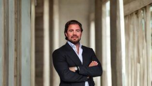 Daniel Vorcaro, fundador do Banco Master, aparece de braços cruzados