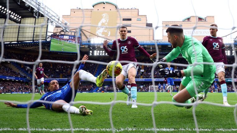 O atacante João Pedro, do Chelsea, dá carrinho para marcar o primeiro gol da partida contra o Burnley