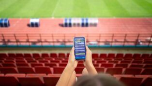 Pessoa com as mãos no celular em site de aposta online