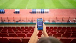 Pessoa com as mãos no celular em site de aposta online