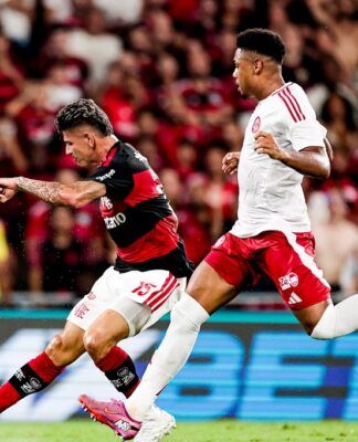 Jogador do Flamengo em disputa de bola com atleta do Inter