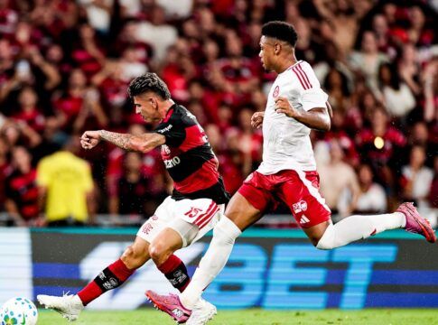 Jogador do Flamengo em disputa de bola com atleta do Inter