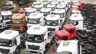 Diversos caminhões novos num pátio