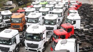 Diversos caminhões novos num pátio