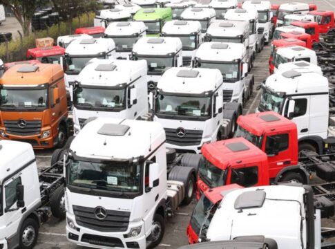 Diversos caminhões novos num pátio