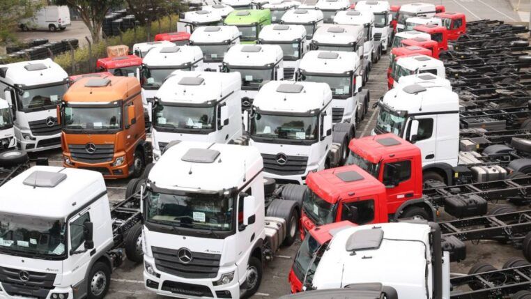 Diversos caminhões novos num pátio
