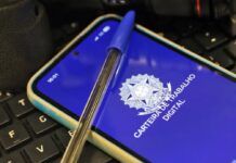 Imagem da carteira de trabalho virtual, na tela de um celular, e uma caneta