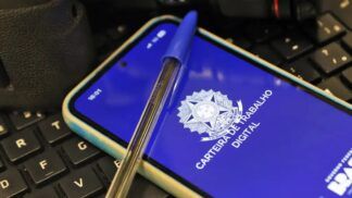 Imagem da carteira de trabalho virtual, na tela de um celular, e uma caneta