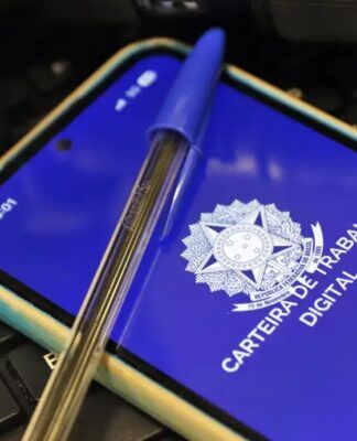 Imagem da carteira de trabalho virtual, na tela de um celular, e uma caneta