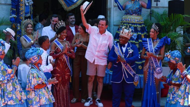 Eduardo Paes faz gesto segurando chapéu no carnaval