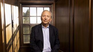 Larry Summers posa para foto sentado à frente de uma janela
