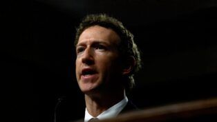 Mark Zuckerberg aparece de terno e gravata diante de um fundo escuro