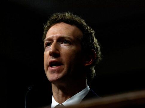 Mark Zuckerberg aparece de terno e gravata diante de um fundo escuro