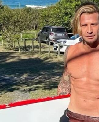 Ex-modelo carrega prancha de surfe