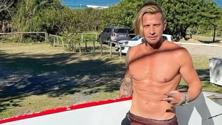 Ex-modelo carrega prancha de surfe