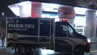 Carro do IML em frente à cena do crime.