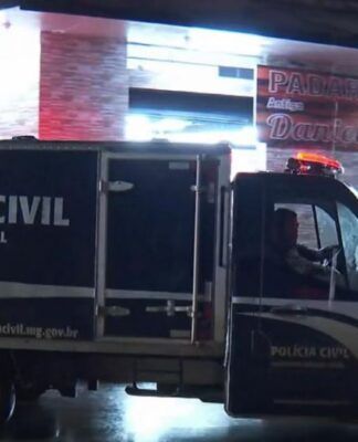 Carro do IML em frente à cena do crime.