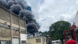 Fogo atinge empresa no bairro Pauliceia, na região do ABC paulista, com densa coluna de fumaça visível a distância; não há registro de feridos no local