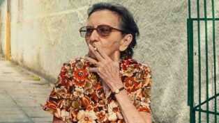 Atriz Tânia Maria fuma um cigarro durante filmagem de "O Agente Secreto"