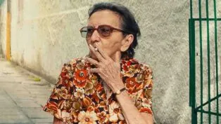 Atriz Tânia Maria fuma um cigarro durante filmagem de "O Agente Secreto"