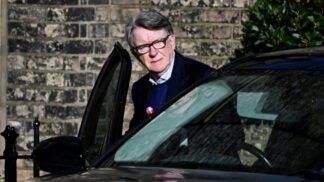 Peter Mandelson entra em um carro de cor escura