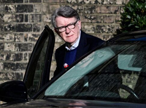 Peter Mandelson entra em um carro de cor escura