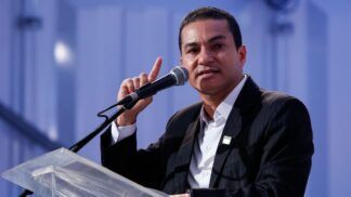 Marcos Pereira gesticula enquanto discursa ao microfone