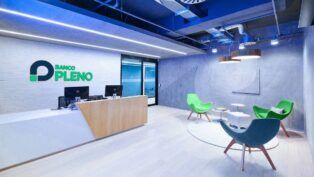 Imagem do escritório do banco, com cadeiras e computadores