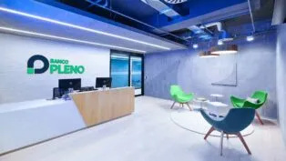 Imagem do escritório do banco, com cadeiras e computadores