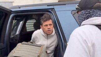 Brasileiro em carro, algemado por agentes do ICE