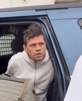 Brasileiro em carro, algemado por agentes do ICE