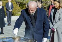 Lula com sua luva de quatro dedos durante cerimônia na Coreia do Sul