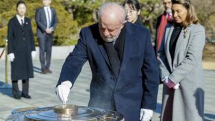 Lula com sua luva de quatro dedos durante cerimônia na Coreia do Sul