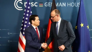 Dois homens apertam mãos em frente às bandeiras de Estados Unidos Alemanha: Marco Rubio e Friedrich Merz