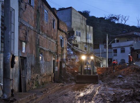 Soldados do Corpo de Bombeiros e voluntários fazem busca e resgate de pessoas em escombros de casas soterradas por lama após fortes chuvas