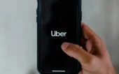 uber Uma mão mexe em um celular com o aplicativo da Uber na tela