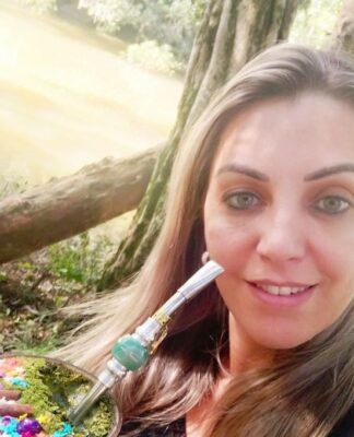 Roseli Vanda Pires Albuquerque tomando chimarrão em espaço público aberto, aparentemente um parque, perto de uma árvore