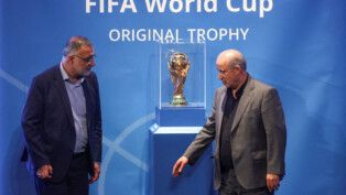 Duas autoridades iranianas observam a taça da Copa do Mundo
