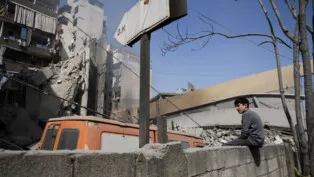 Garoto senta no muro diante de prédio destruído por ataques israelenses