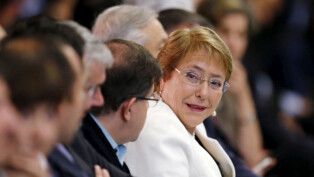 Ex-presidente do Chile Michelle Bachelet olha para homens ao seu lado