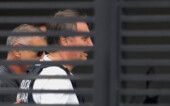 Jair Bolsonaro chega a sua casa e é visto através das frestas do portão