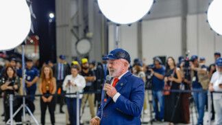 Presidente Lula fala ao microfone durante evento em fábrica