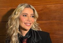 Luiza Possi sorri em foto posada, vestindo paletó, camisa preta e gravata