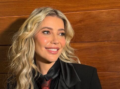 Luiza Possi sorri em foto posada, vestindo paletó, camisa preta e gravata